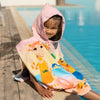 Barn vid poolen i rosa badponcho