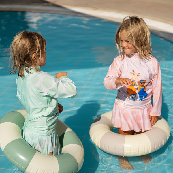 Barn badar i poolen med lollo och bernie uv-kläder