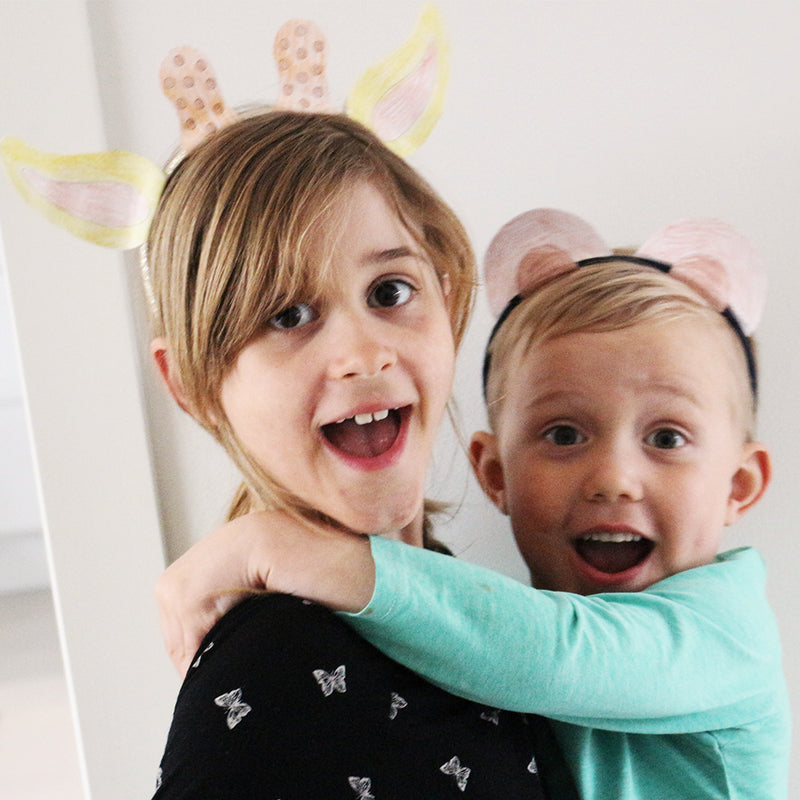 Lapset itse tehdyissä diadeemeissa